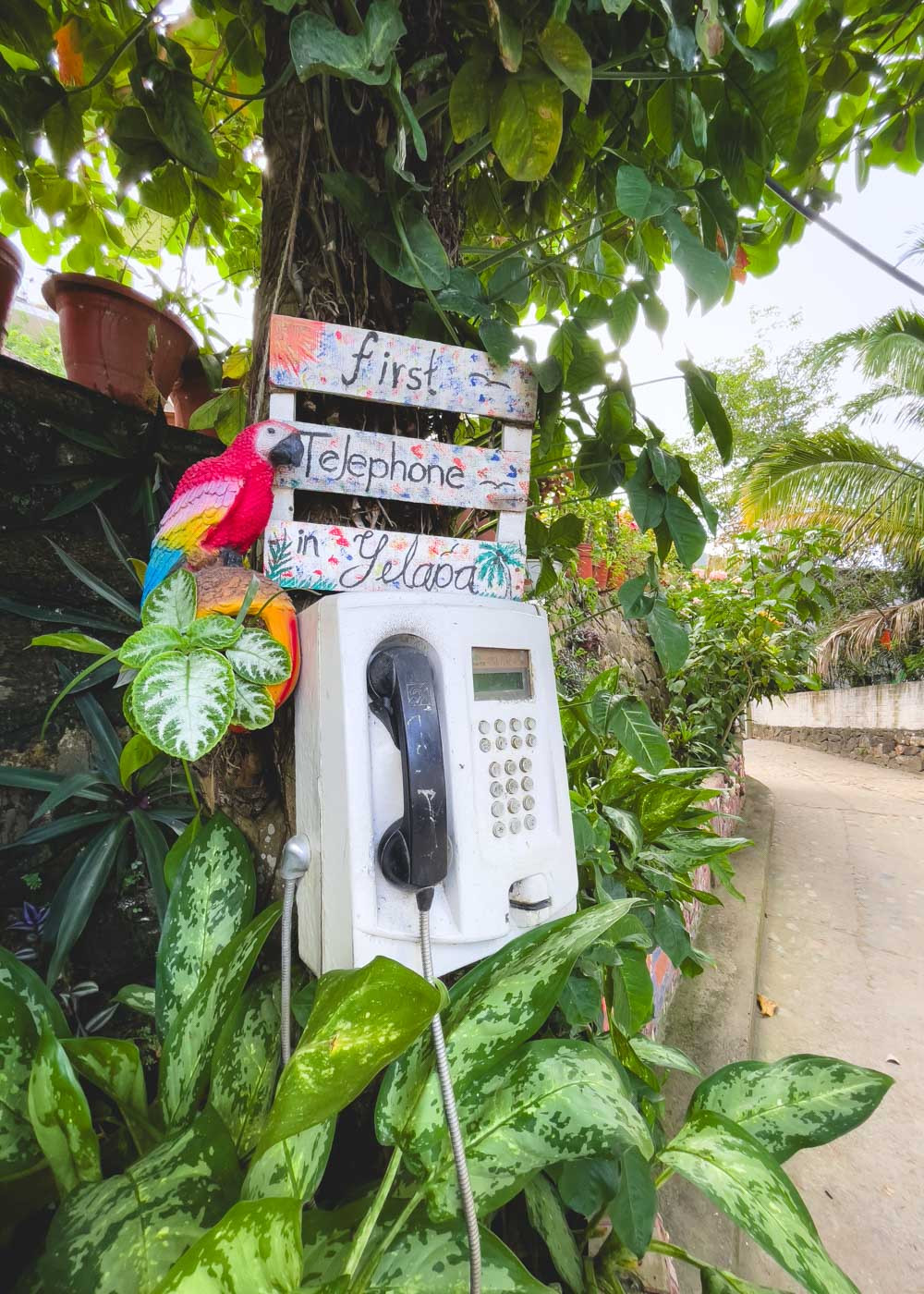 A vintage payphone with a sign indicating it still functions in Yelapa.