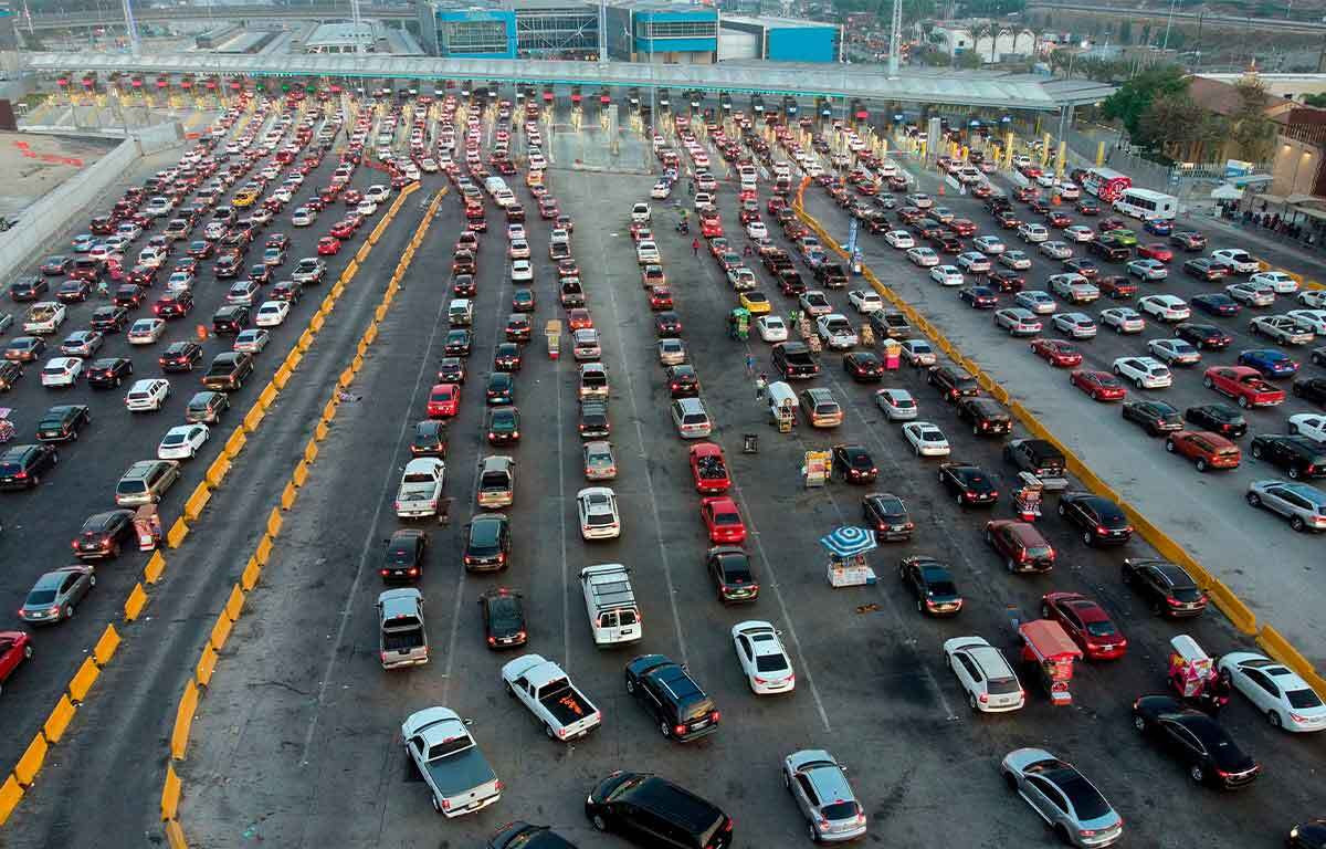 The US-Mexico border line at Tijuana, often congested with long wait times, a common experience for surfers in Mexico returning to the US.