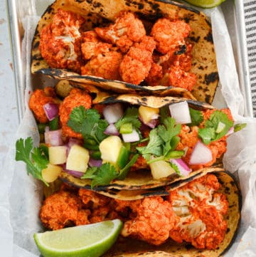 Three vegan al pastor tacos, showcasing a plant-based interpretation of this Mexican meat dish.