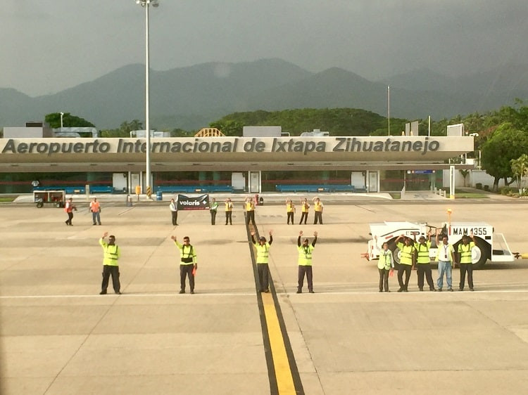 volaris crew waves goodbye to us from the tarmac on takeoff