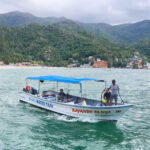 Water taxi navigating the waters surrounded by Yelapa's lush mountains.