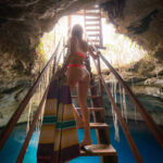 Descending into the cool depths of Cenote Noh-Mozon near Merida, Mexico, via sturdy wooden stairs.