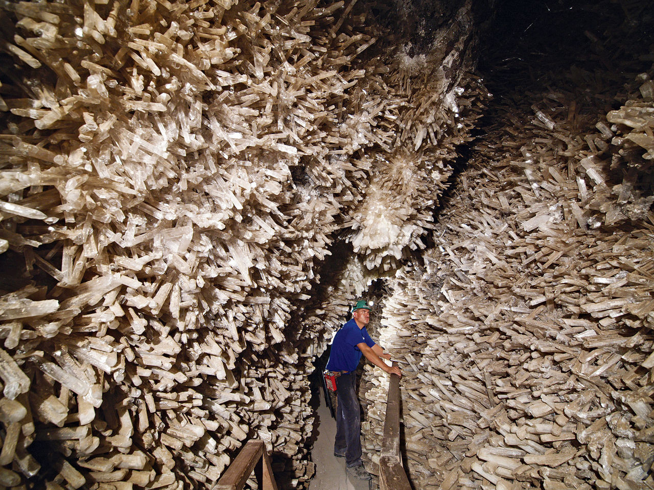 Image shows a person in the narrow Cave of Swords with swordlike crystals covering the walls on both sides.