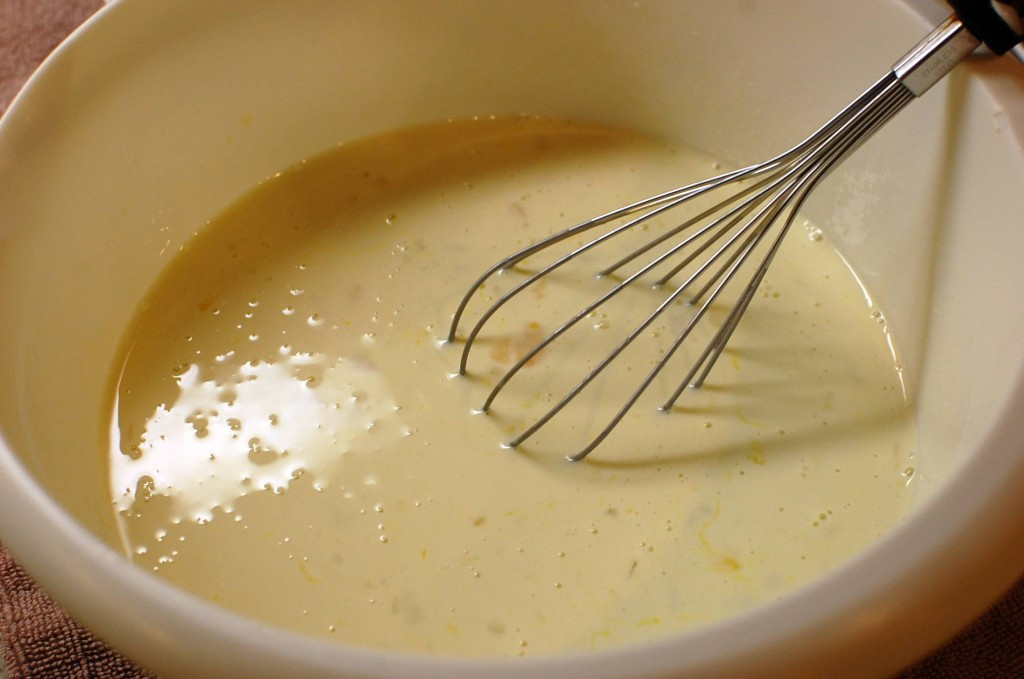 Custard ingredients being whisked together in a bowl.