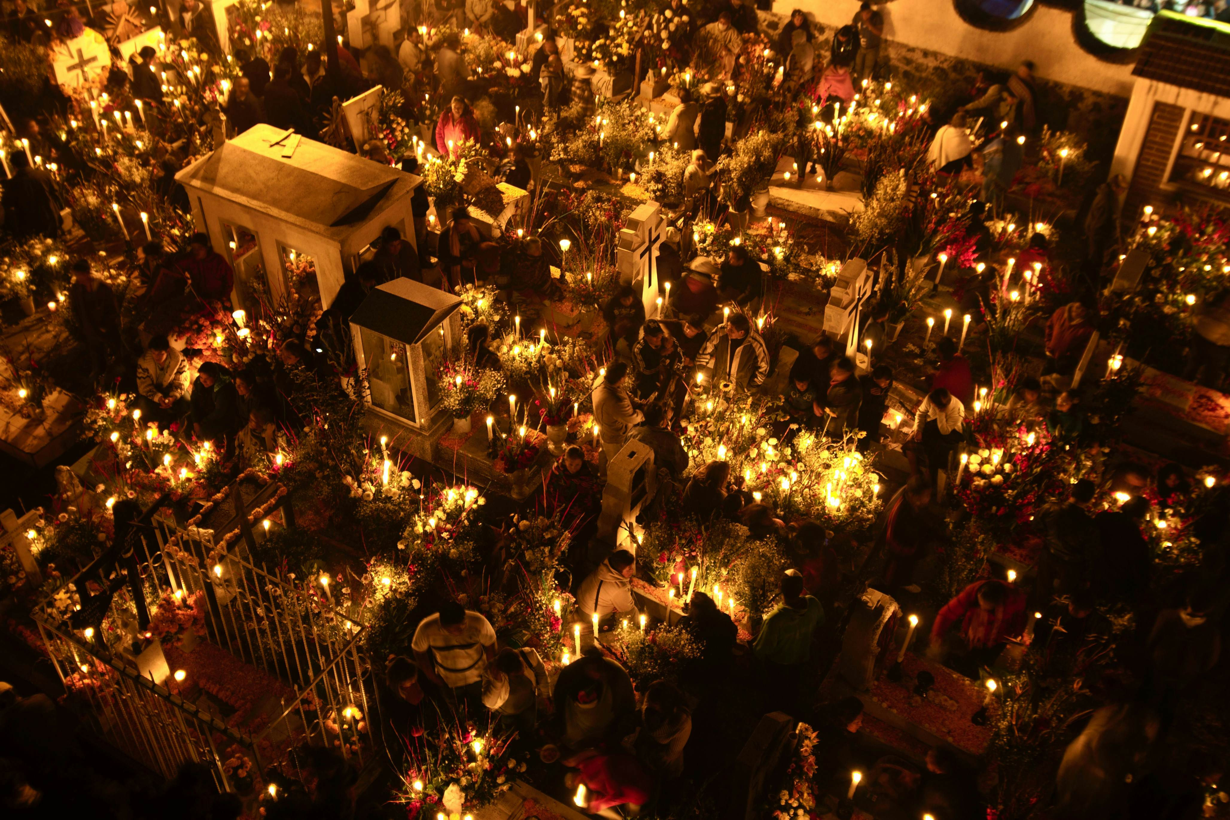 Gravesites illuminated by candlelight during Day of the Dead celebrations in San Andres. Shutterstock