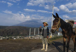 Jose Marcos, a local farmer, gazes warily at Popocatepetl volcano, locally known as El Popo, reflecting the community's deep connection to the volcano's spirit.