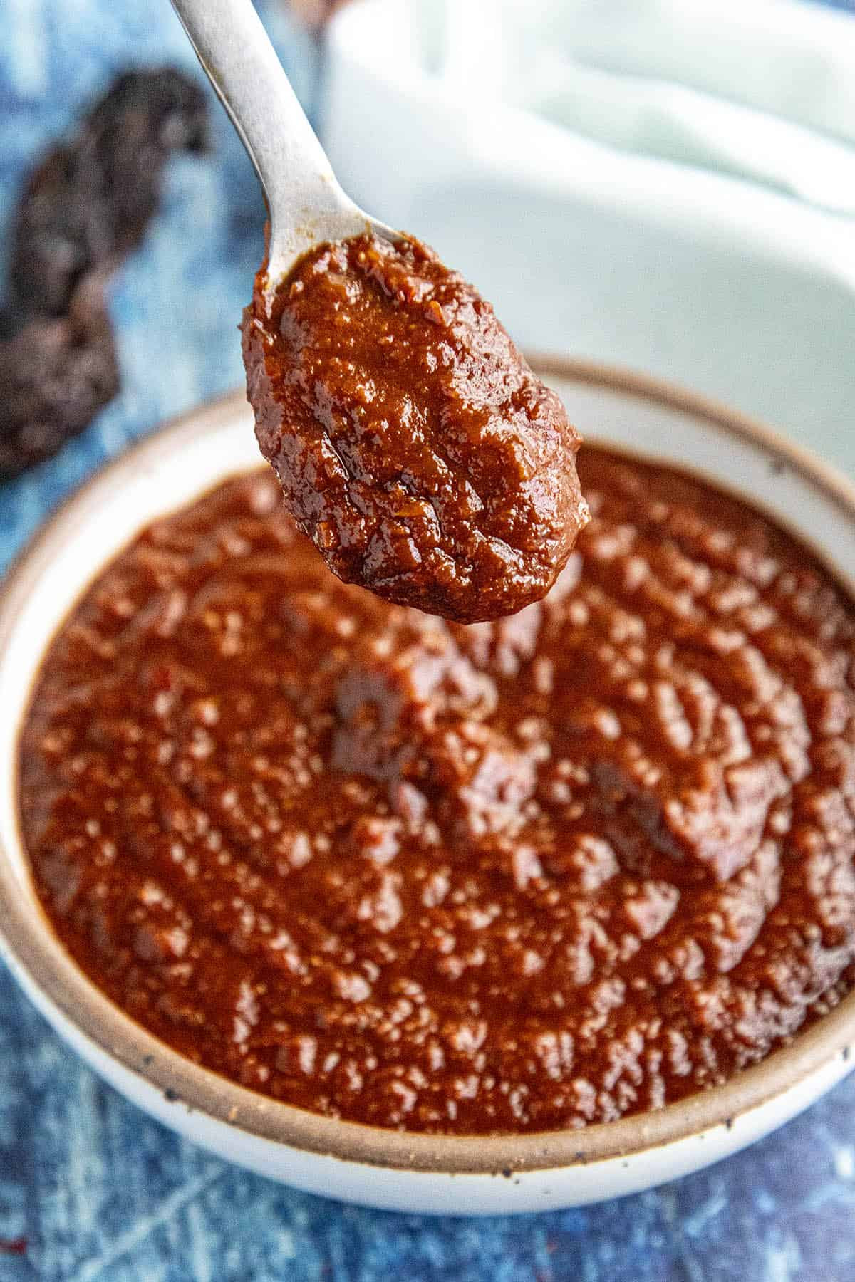 Preparing ingredients for adobo sauce in a Mexican kitchen, showcasing the intersection of culinary tradition and cultural identity.