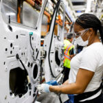 A woman assembling a door of a Ford F-150 full-size half-ton pickup truck at the Dearborn plant in the U.S.A.