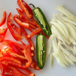 Ingredients for Mexican hot dogs with fresh red bell pepper, jalapeño, and onions