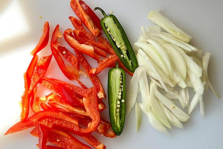 Ingredients for Mexican hot dogs with fresh red bell pepper, jalapeño, and onions