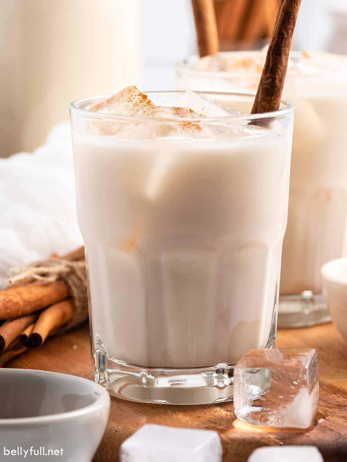 Horchata in a glass with ice and a cinnamon stick