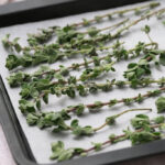 Fresh oregano leaves on baking sheet on parchment paper