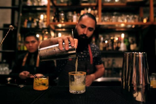 Mexican bartender serving a cocktail at a local bar in Progreso