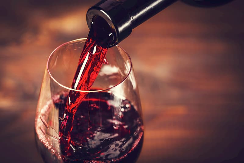 A bottle of Mexican wine and a glass, set against a vineyard backdrop, emphasizing the growing wine culture and the quality of Mexican wines.