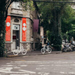 Cyclists and a motorbike parked on the tranquil street, encapsulating the lively spirit of Roma Norte, Mexico City.