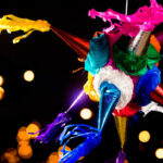 Breaking a traditional star-shaped piñata at a Posada celebration, Mexico