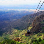 Sandia Mountains at sunset in Albuquerque, New Mexico, showcasing the city lights below.