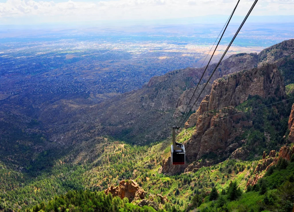 Sandia Mountains at sunset in Albuquerque, New Mexico, showcasing the city lights below.