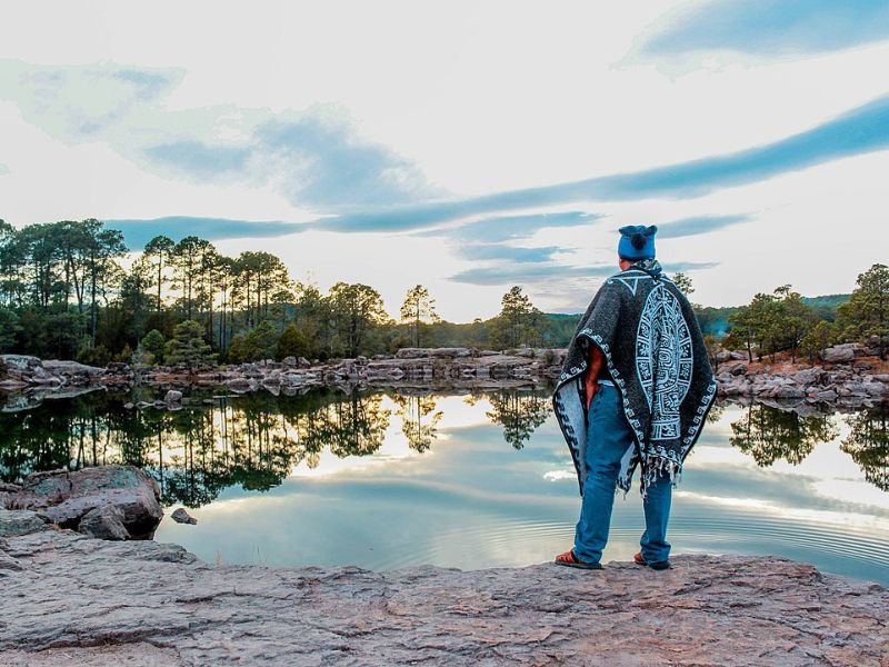 Man in a poncho at a lake in Sierra de Mexiquillo, Durango, Mexico