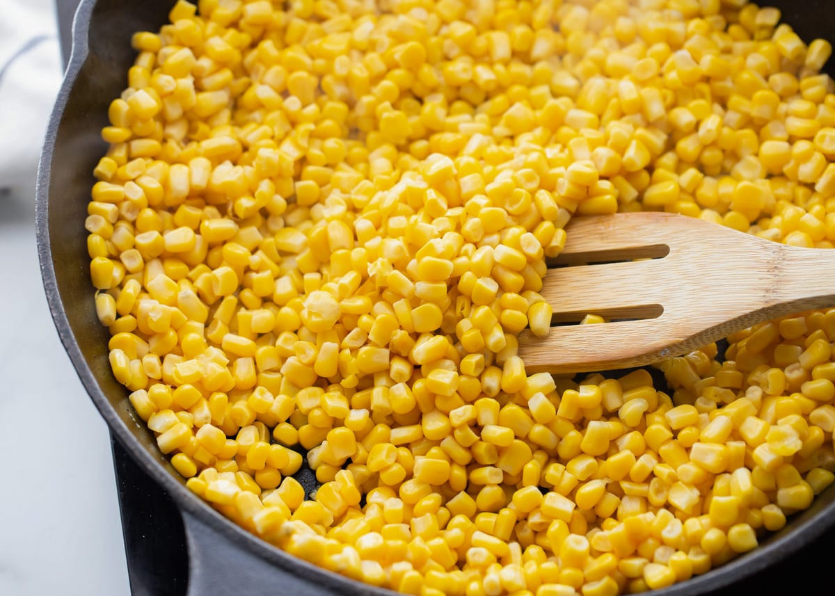 Corn kernels piled in a cast iron skillet, ready to be transformed into delicious Mexican street corn with canned corn.