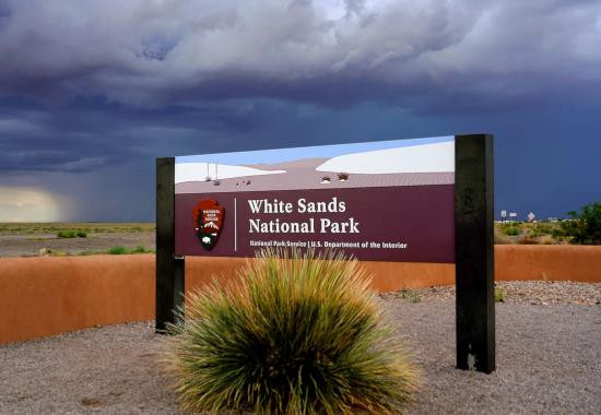 A sign marking the entrance to White Sands National Park, emphasizing its status as a national park and its significance in preserving the unique gypsum dunefield.