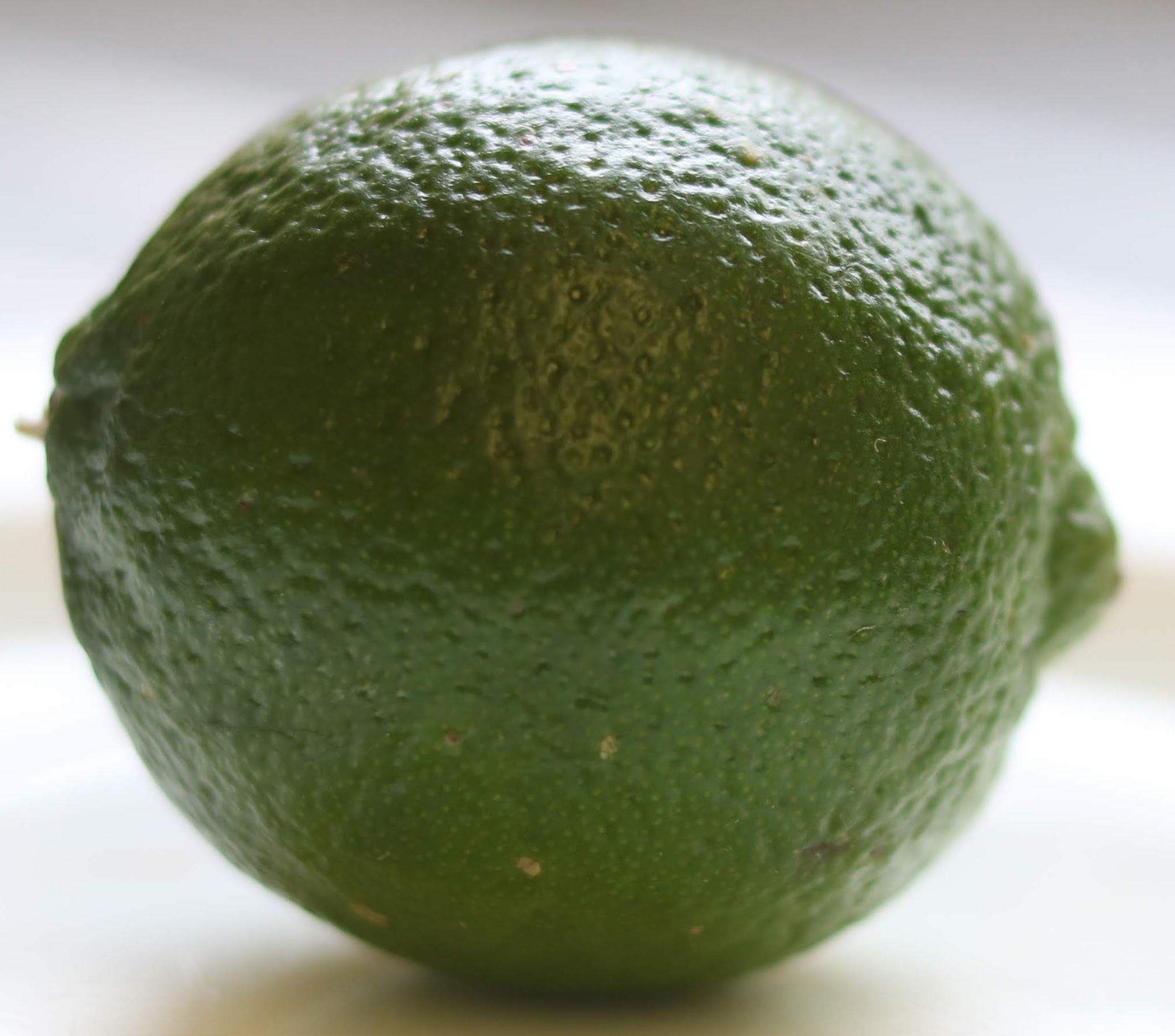 Whole lime. A close-up shot of a whole, ripe lime