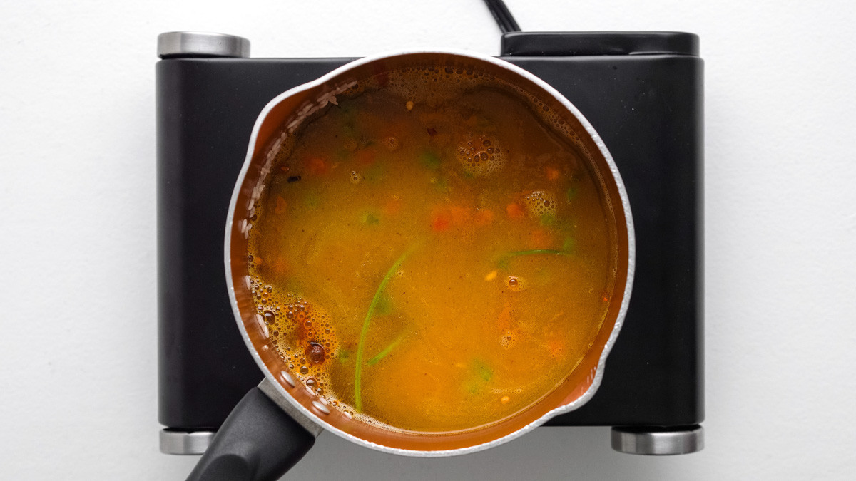 Rice cooking in a pot with visible spices.