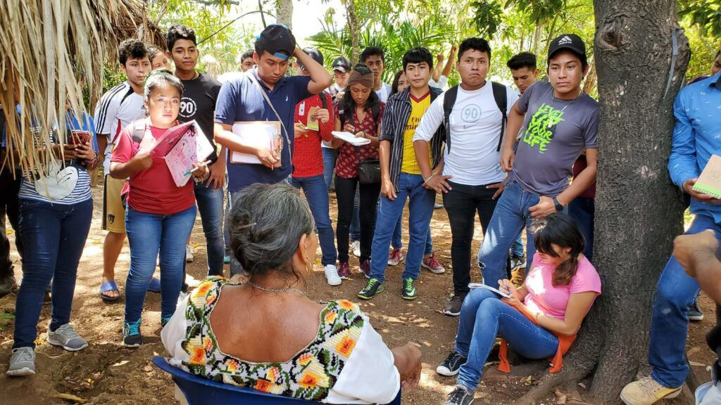 Young participants in Our Forest, Our Future gather around an elder in Calakmul, Mexico, to learn about medicinal plants.