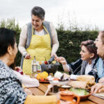 mexican-family-gathered-around-the-dinner-table-making-fresh-guacamole