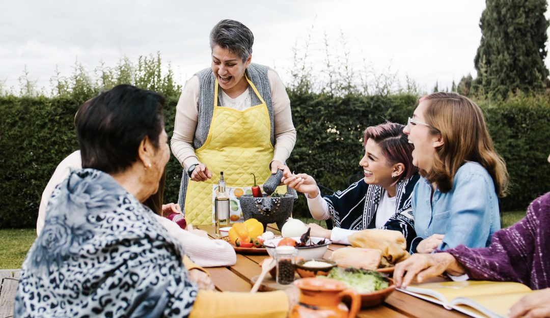 mexican-family-gathered-around-the-dinner-table-making-fresh-guacamole