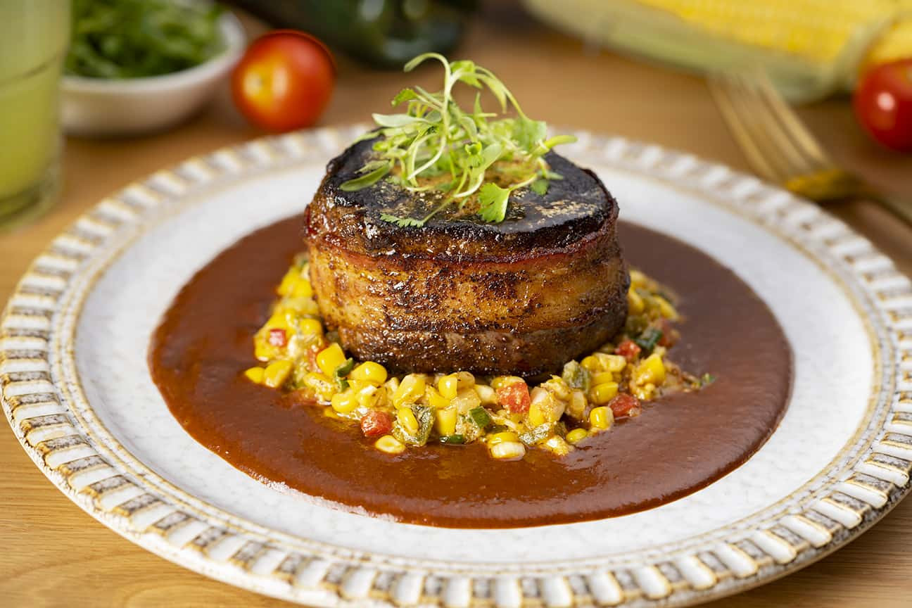 The Oaxacan filet, served over a cherry mole with Mexican corn relish and topped with chile verde butter at VERDAD