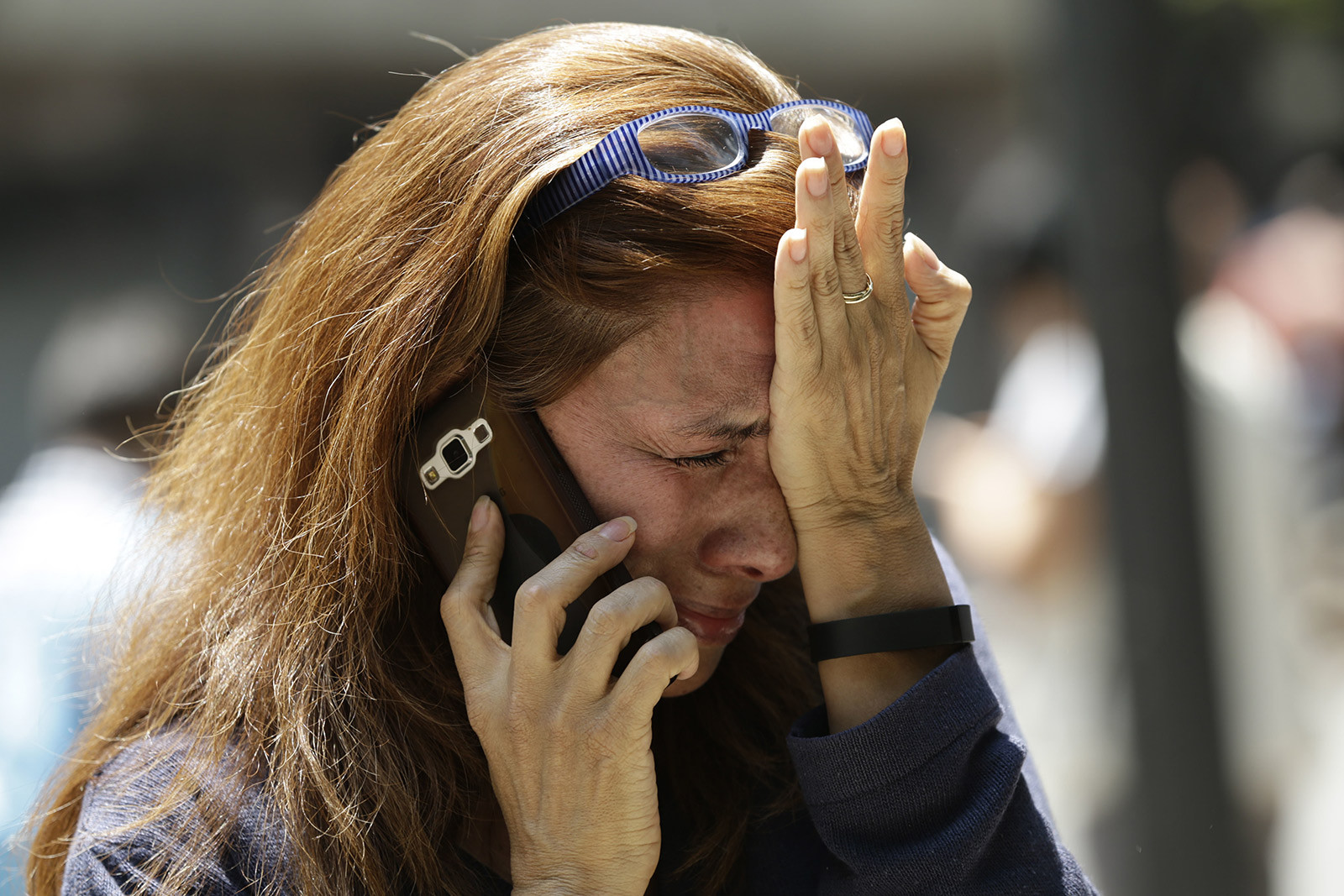 Woman in Mexico City trying to reach people on her cell phone after the earthquake
