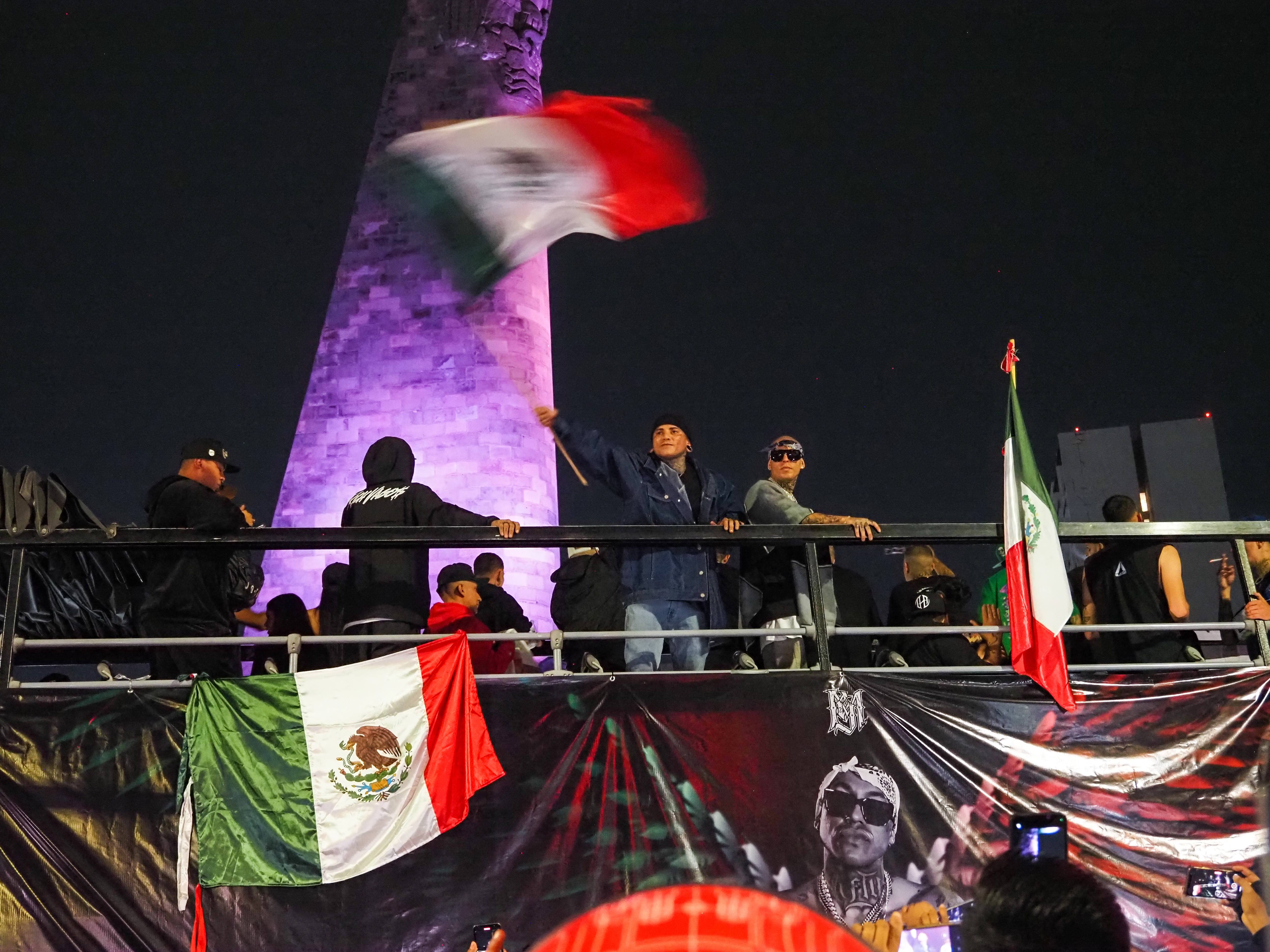 Mexican rappers El Pinche Mara (L) and Tiro Loko (R) arrive waving a flag above a photo of Lefty with angel wings. (Photo: Nathaniel Janowitz for VICE News.)