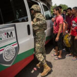 Mexican Marine orders migrants off a bus