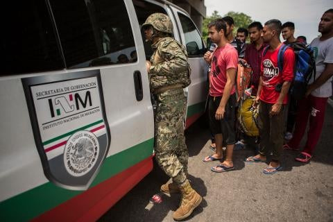 Mexican Marine orders migrants off a bus