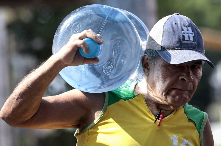 A man carries a jerrycan of water.