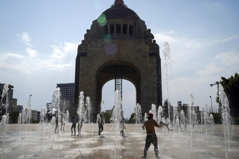 People frolic at the water fountain .