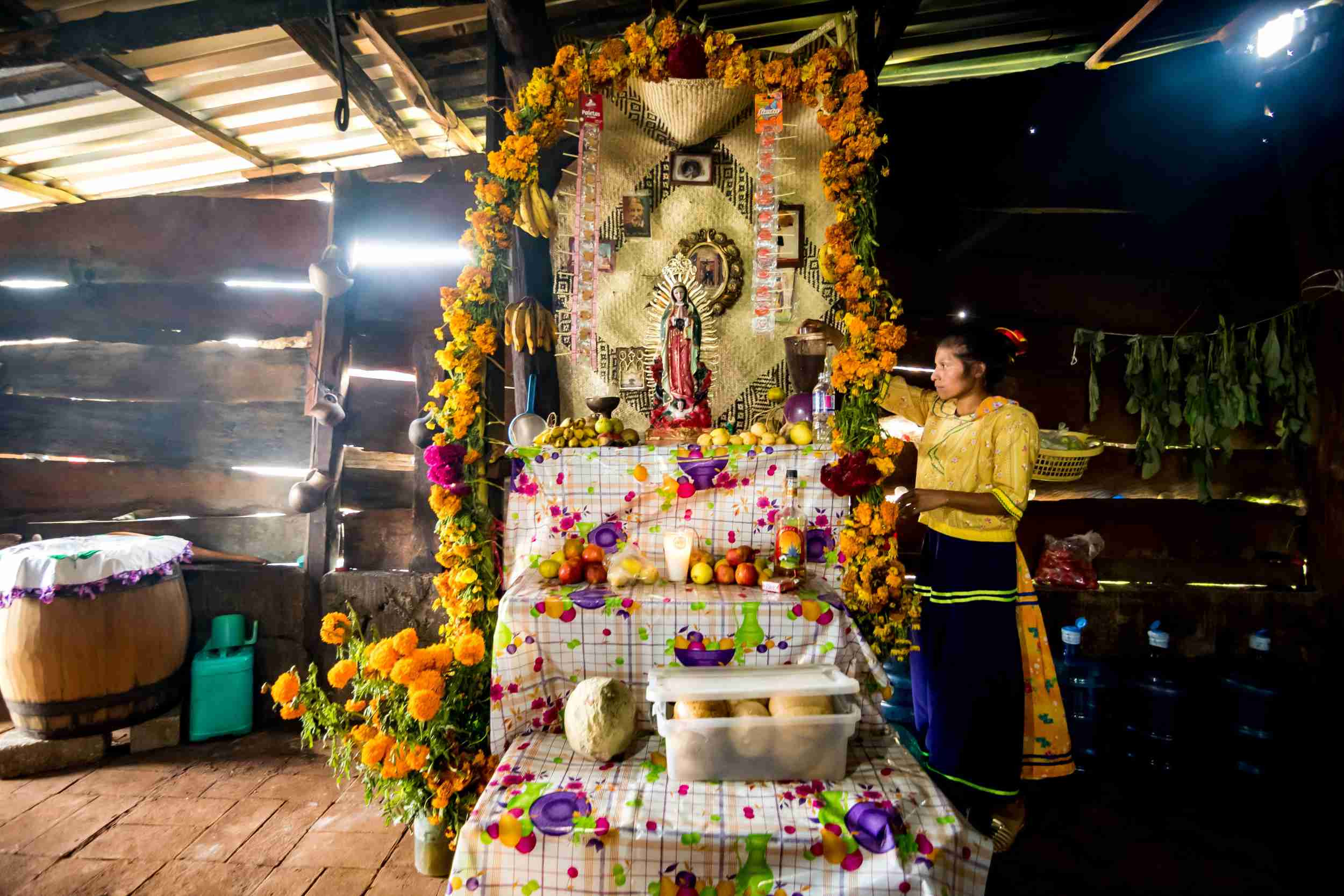 A woman from the community decorates an altar, showcasing a blend of culture and tradition in Mexico.