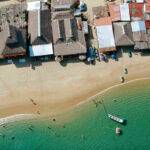 Stalls on the beach near the sea with boats sailing in Puerto Vallarta, offering a picturesque view of coastal life.