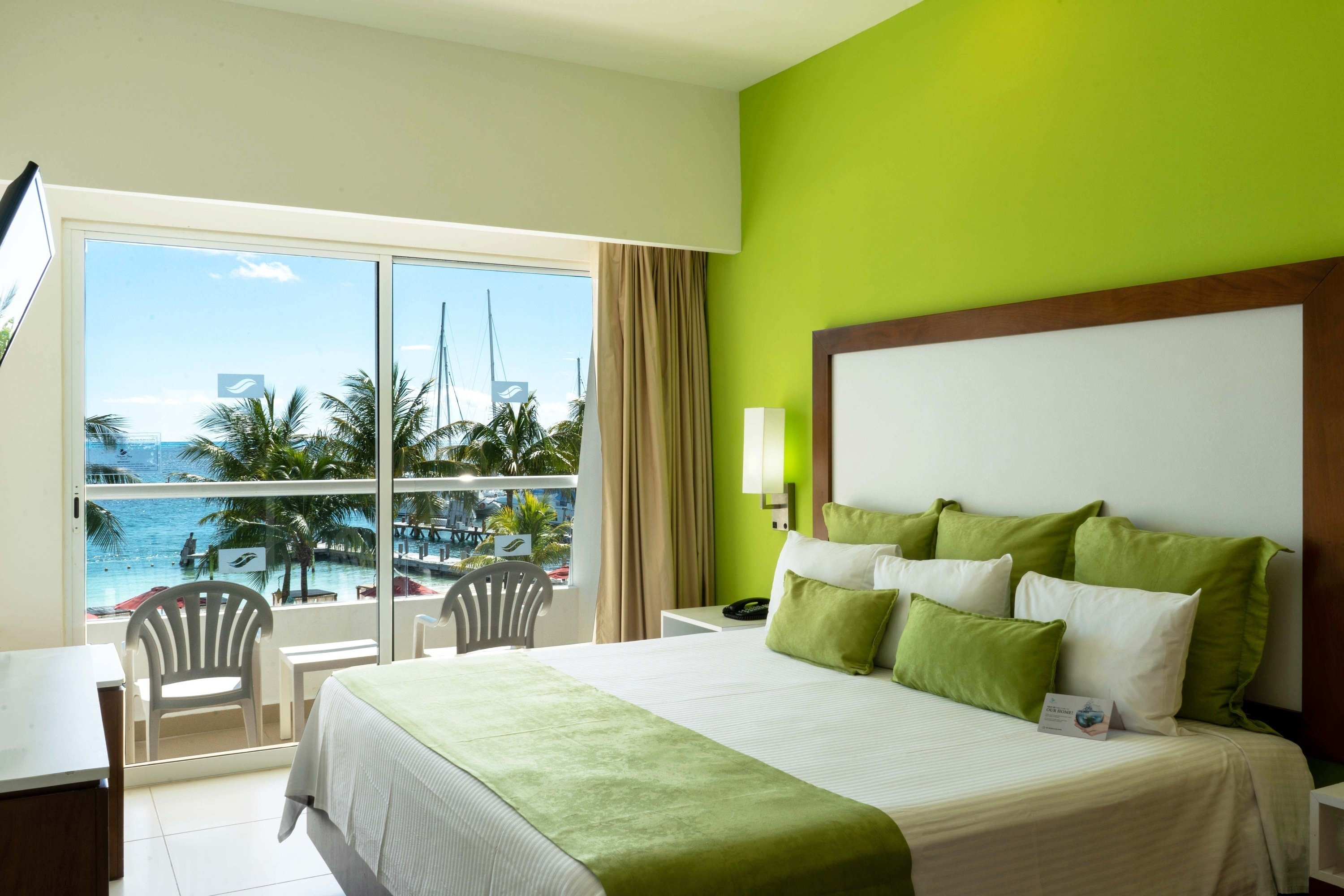 Superior Sea View Room at Cancun Bay Resort featuring a king-size bed and a private terrace with ocean views, perfect for couples or solo travelers seeking relaxation.