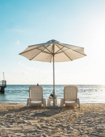 Sunset view from Cancun Bay Hotel, showing a couple enjoying a quiet moment on the beach, emphasizing the resort's romantic and tranquil atmosphere.