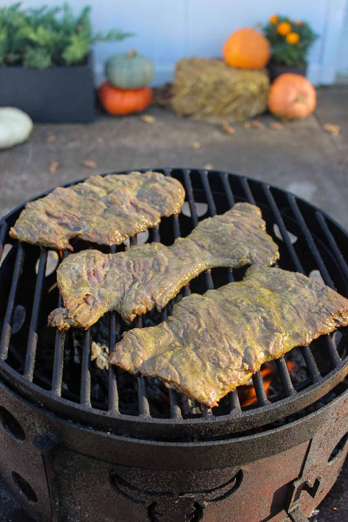 The raw steaks hitting the grill. 