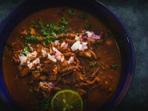 Bowl of Birria Stew garnished with cilantro and onions