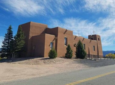 The Adobe Sacred Heart Catholic Church from the side and blue skies