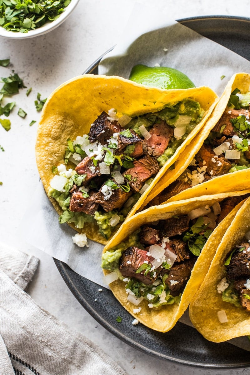 Carne Asada Tacos ready to serve with a variety of toppings.