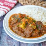 Carne con Papas (Beef and Potatoes) on two stacked white plates with rice.
