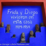 A blue wall with pre-Hispanic figurines and the text