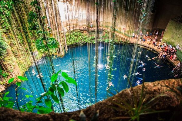 Crowds enjoying a refreshing swim in Cenote Ik-Kil in Mexico.