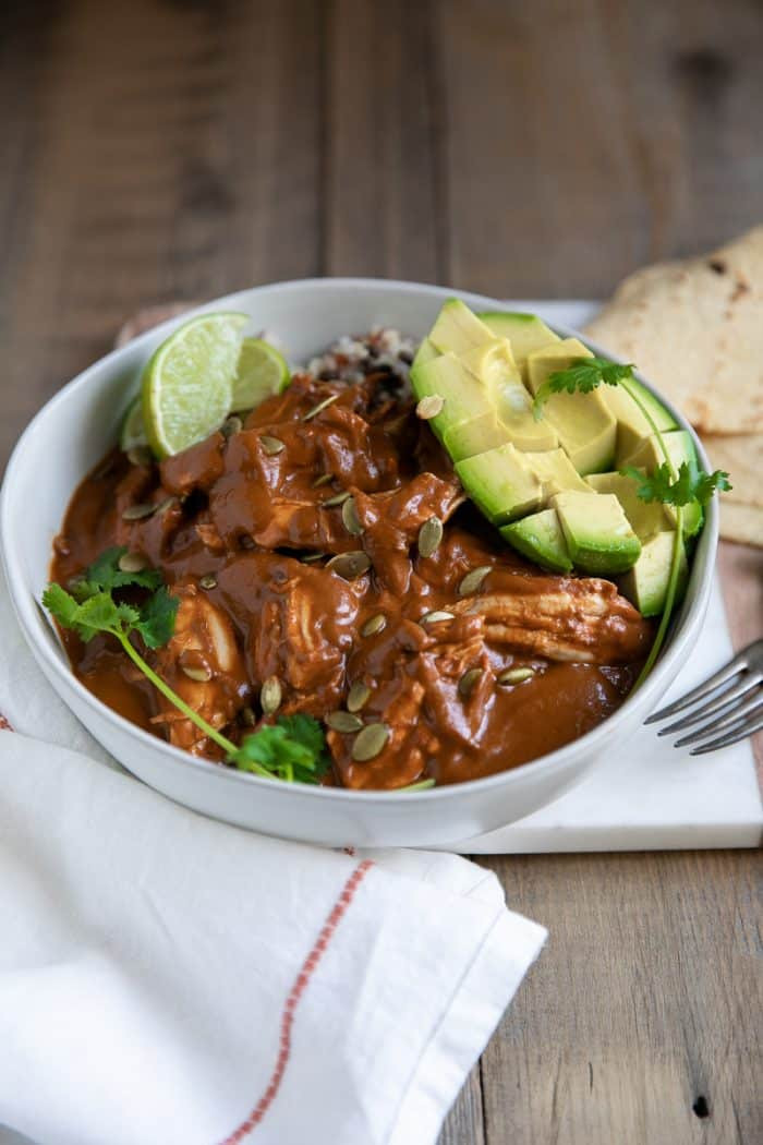 Chicken Mole served with a side of rice and garnished with sesame seeds
