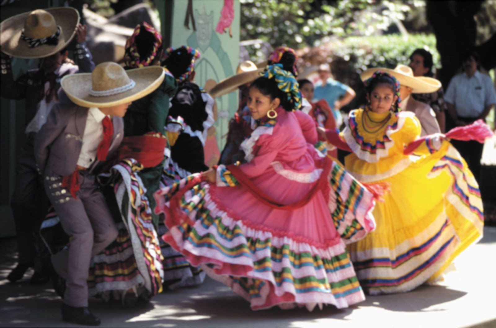 Children in traditional Mexican clothing dancing at a Cinco de Mayo celebration.